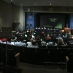 people in an auditorium watching a presentation on stage