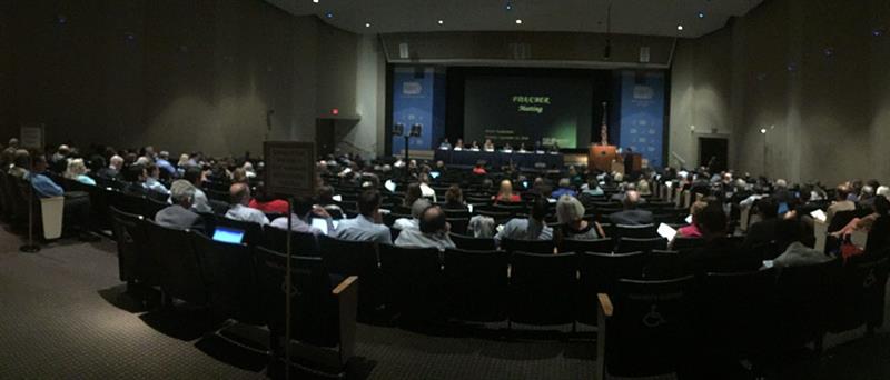 people in an auditorium watching a presentation on stage