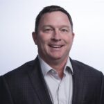 portrait of a man in a dark suit coat and light button up shirt
