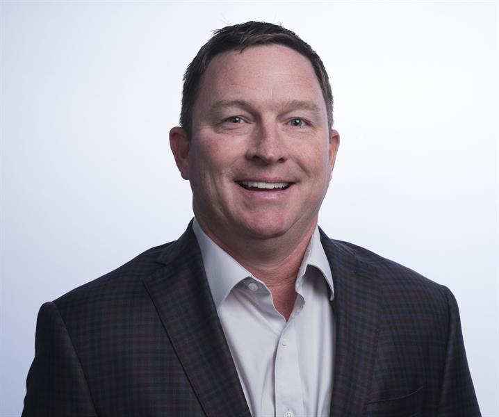 portrait of a man in a dark suit coat and light button up shirt