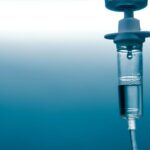closeup of medical equipment -iv drip- on blue background